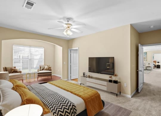 A large bedroom with a ceiling fan and library niche at Avignon Apartments in Olathe, Kansas