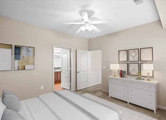 A large bedroom with a ceiling fan and attached master bathroom.