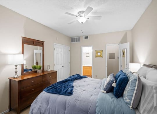 a bedroom with a bed and a ceiling fan at Creekview Apartment Homes, Dallas, 75254