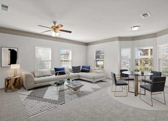 a living room with a couch a table and a ceiling fan at Stonepost Crossing Apartments, Overland Park, KS, 66213