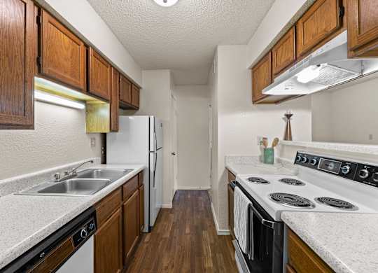 A kitchen with wooden cabinets and a white stove top oven.