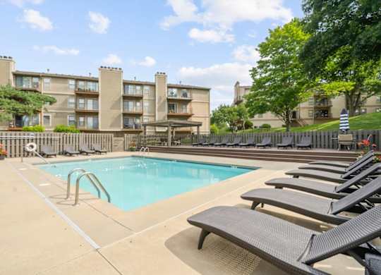 Pool surrounded by Lounge chairs at Cloverset Active Adult Apartments, Kansas City, MO