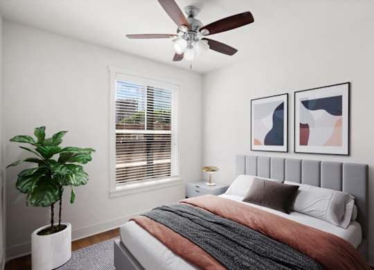 A bedroom with a ceiling fan and window at The Mirabelle pet-friendly apartments on the Plaza in Kansas City, MO
