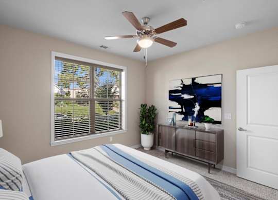 a bedroom with a large window and a ceiling fan at The Dorset, Kansas City, 64112