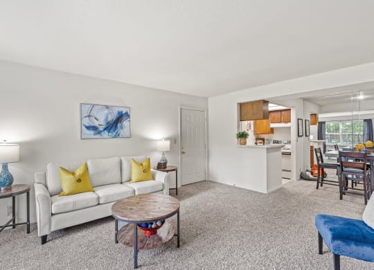 a living room with a white couch and yellow pillows at Pebblebrook, Kansas