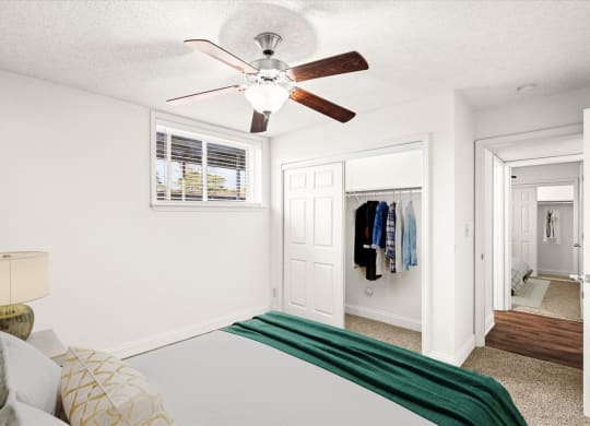 a bedroom with a bed and a ceiling fan at Fiesta Square Apartments & Townhomes, Overland Park, KS, 66212