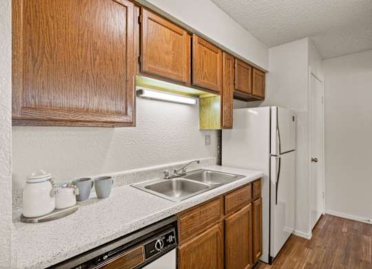 A kitchen with wooden cabinets and a white refrigerator.
