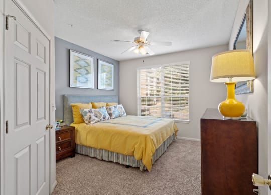 a bedroom with a bed and a ceiling fan  at Claremont, Overland Park