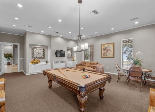 a game room with a pool table and a television at The Clairborne Apartment Homes, Grand Prairie, TX, 75050