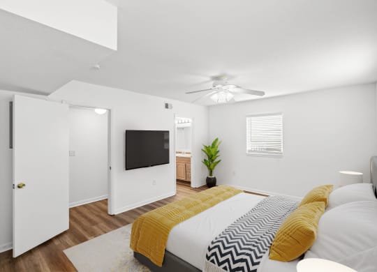 a bedroom with a large bed and a ceiling fan