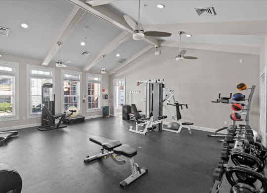 A spacious gym with a variety of equipment and a large mirror on the wall.