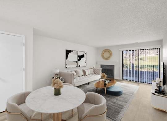 A living room with a white couch, a coffee table, and a large window.