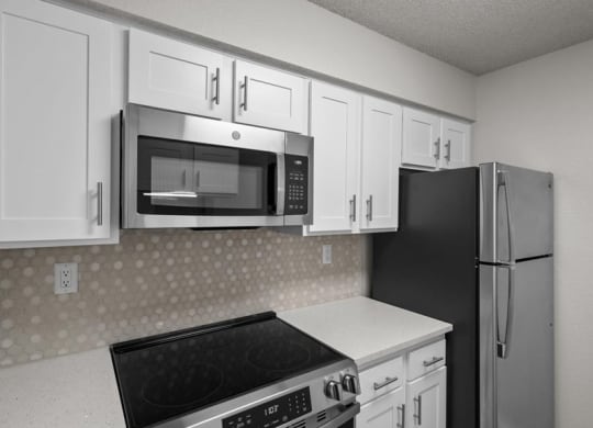 a kitchen with white cabinets and a stove and a refrigerator at Highland Park Apartment Homes, Kansas, 66214