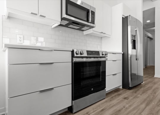 a kitchen with white cabinets and a stove and a refrigerator