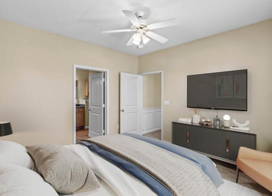 A bedroom with a ceiling fan and attached bathroom