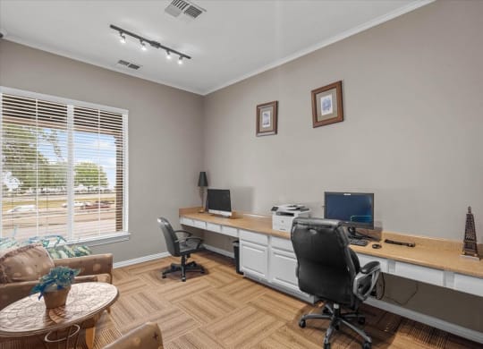 a home office with two computers and a coffee table at The Clairborne Apartment Homes, Texas