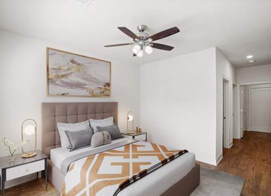 A bedroom with a ceiling fan and hallway closet.
