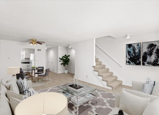 a living room with couches and a table and a staircase