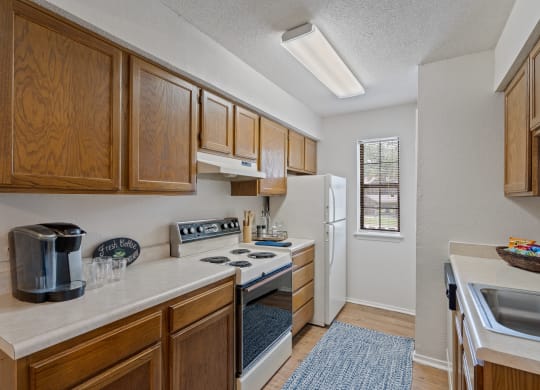 a kitchen with a white refrigerator freezer next to a stove top oven at Waterford Place Apartments & Townhomes, Overland Park, KS