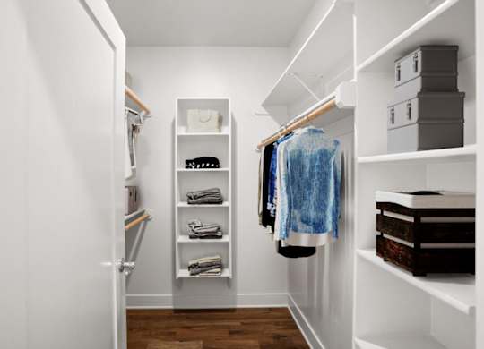 A large walk-in closet with built-in shelves, shoe storage, and clothing racks.