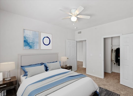 A bedroom with a ceiling fan and large walk in closet.