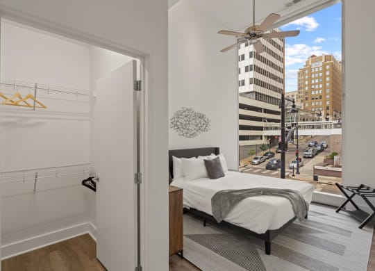 a bedroom with a large window and a city view
