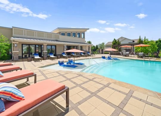 a swimming pool with lounge chairs and umbrellas