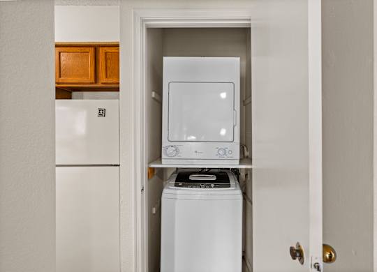 A white washing machine is in a small laundry room.