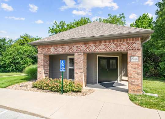 A small brick building with a blue sign in front.