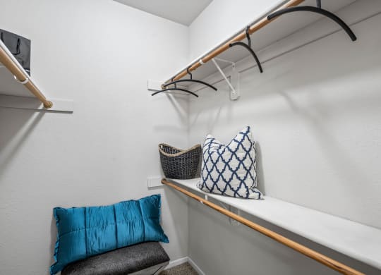 a closet with a shelf and a chair