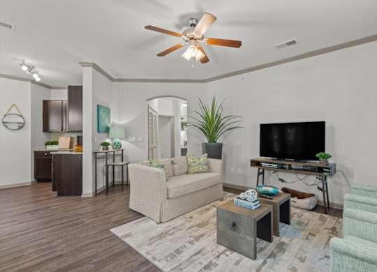 a living room with white walls and a ceiling fan at Stonepost Crossing Apartments, Overland Park, KS