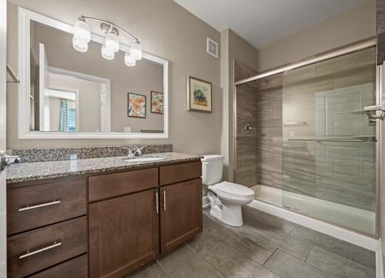 A bathroom with a sink, toilet, and shower.