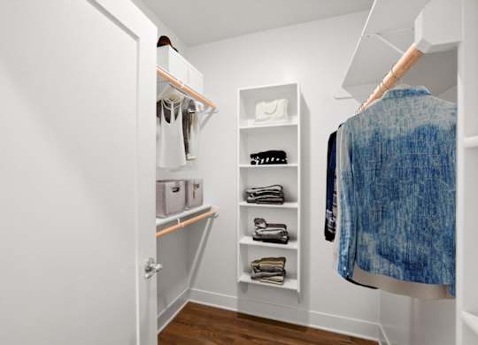A large walk-in closet with built-in shelves, shoe storage, and clothing racks.