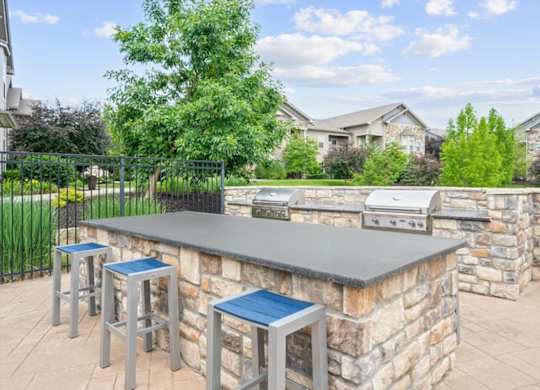 A barbecue grill is on a stone patio.