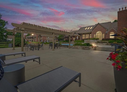 a patio with benches and tables in front of a building at Highland Park Apartment Homes, Kansas, 66214