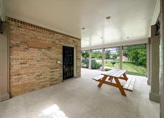 A room with a brick wall and a wooden table.