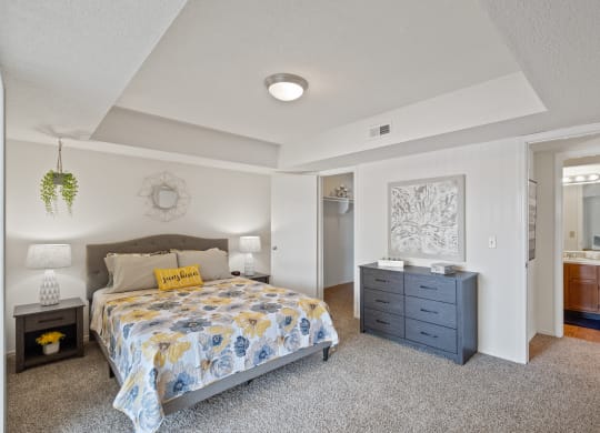 a bedroom with a bed and a dresser at Waterford Place Apartments & Townhomes, Kansas, 66210