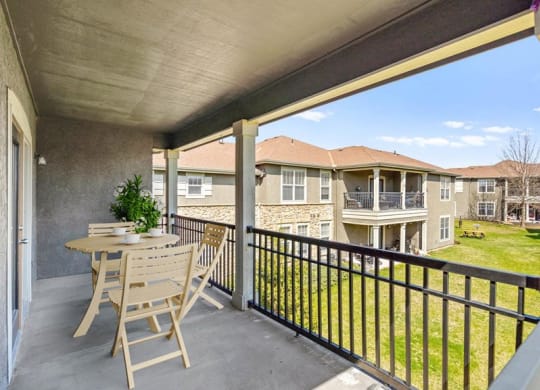 A large fenced in patio overlooking a grassy area