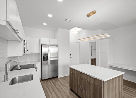 a kitchen with a white counter top and a stainless steel refrigerator