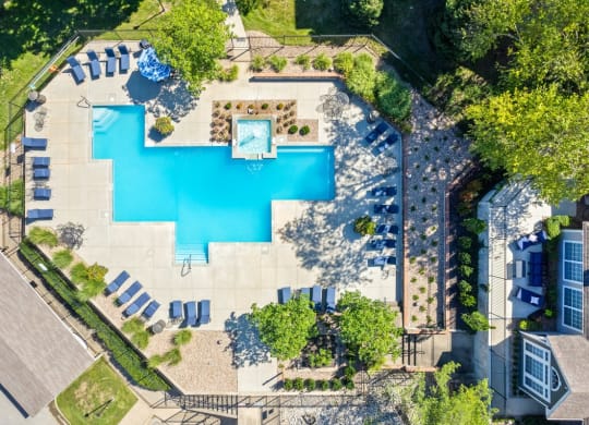 arial view of a swimming pool in a backyard with lounge chairs and treesat Stonebriar Apartments, Overland Park, 66213