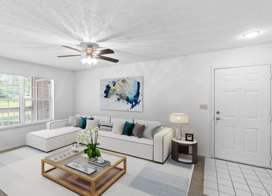a living room with a white couch and coffee table and a ceiling fanat Stonebriar Apartments, Overland Park, 66213