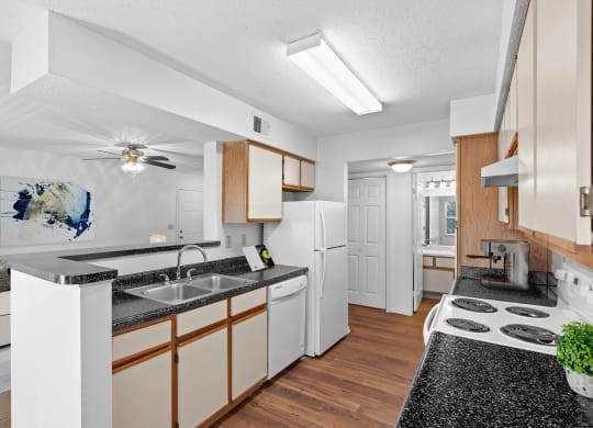 a kitchen with white appliances and wooden cabinetsat Stonebriar Apartments, Kansas, 66213