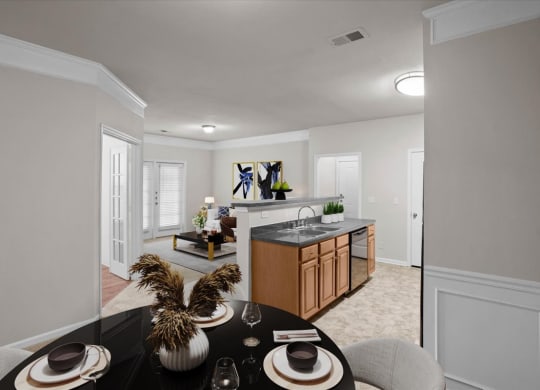 A dining area with crown molding, wainscoting, and a kitchen and living room in the background.