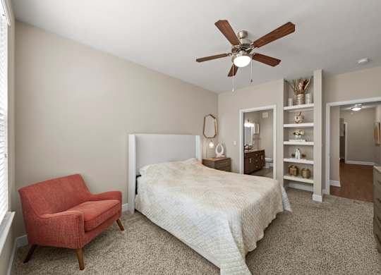 A bedroom with a bed, chair, and shelves.