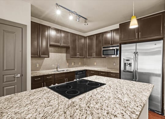 a kitchen with granite countertops and dark wood cabinets