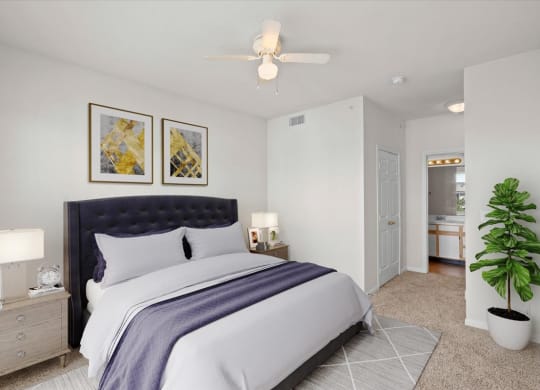 A primary bedroom with a ceiling fan, closet and attached bathroom.