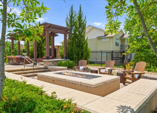 a patio with chairs and a fire pit      and a house