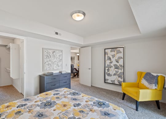 a bedroom with a bed and a dresser at Waterford Place Apartments & Townhomes, Overland Park, KS