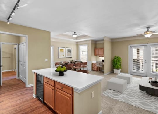 A kitchen with a kitchen island, quartz countertops, a wine cooler, and hardwood floors at Avignon Apartments in Olathe, Kansas