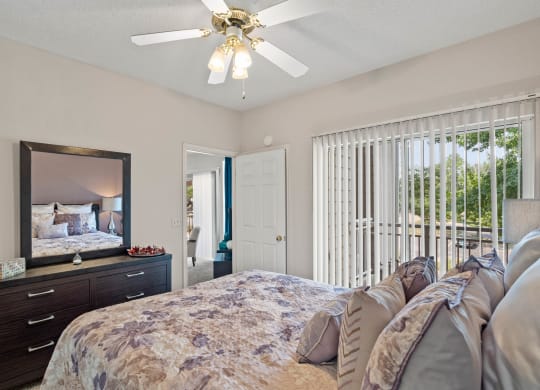 a bedroom with a bed and a ceiling fan  at Claremont, Overland Park, KS